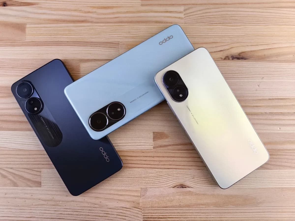 Three foldable smartphones standing partially open side by side on a light studio surface
