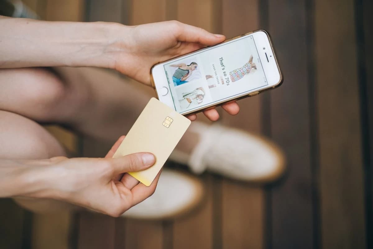 A person holding a smartphone while online shopping, illustrating buy now, pay later debt risks