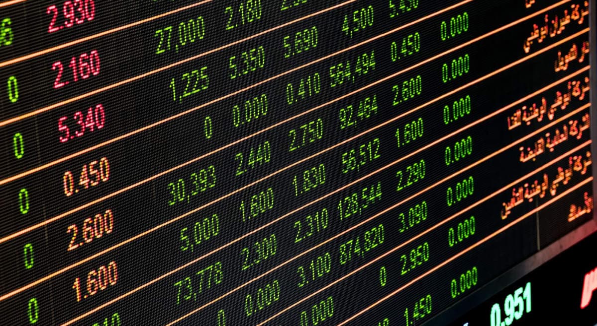 Close-up of a glowing stock market ticker board with red and green market figures