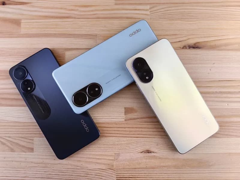 Three foldable smartphones standing partially open side by side on a light studio surface