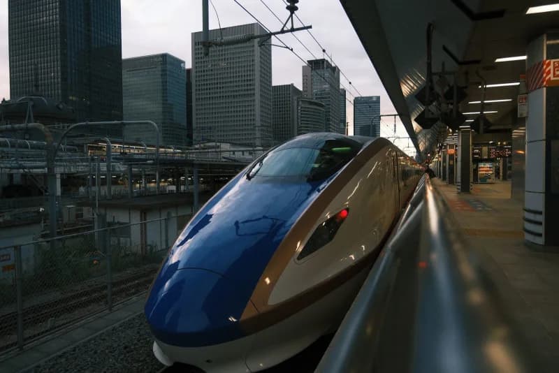 Sleek high-speed train speeding through Canadian countryside at golden hour