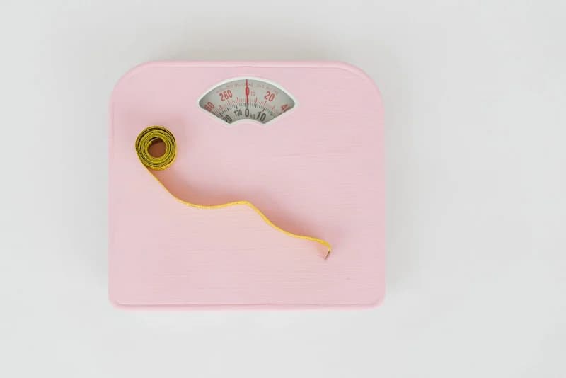A measuring tape resting on a weighing scale, symbolizing weight management after stopping GLP-1 drugs
