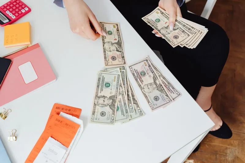 Paper bills beside a calculator on a table, representing a subscription cost audit