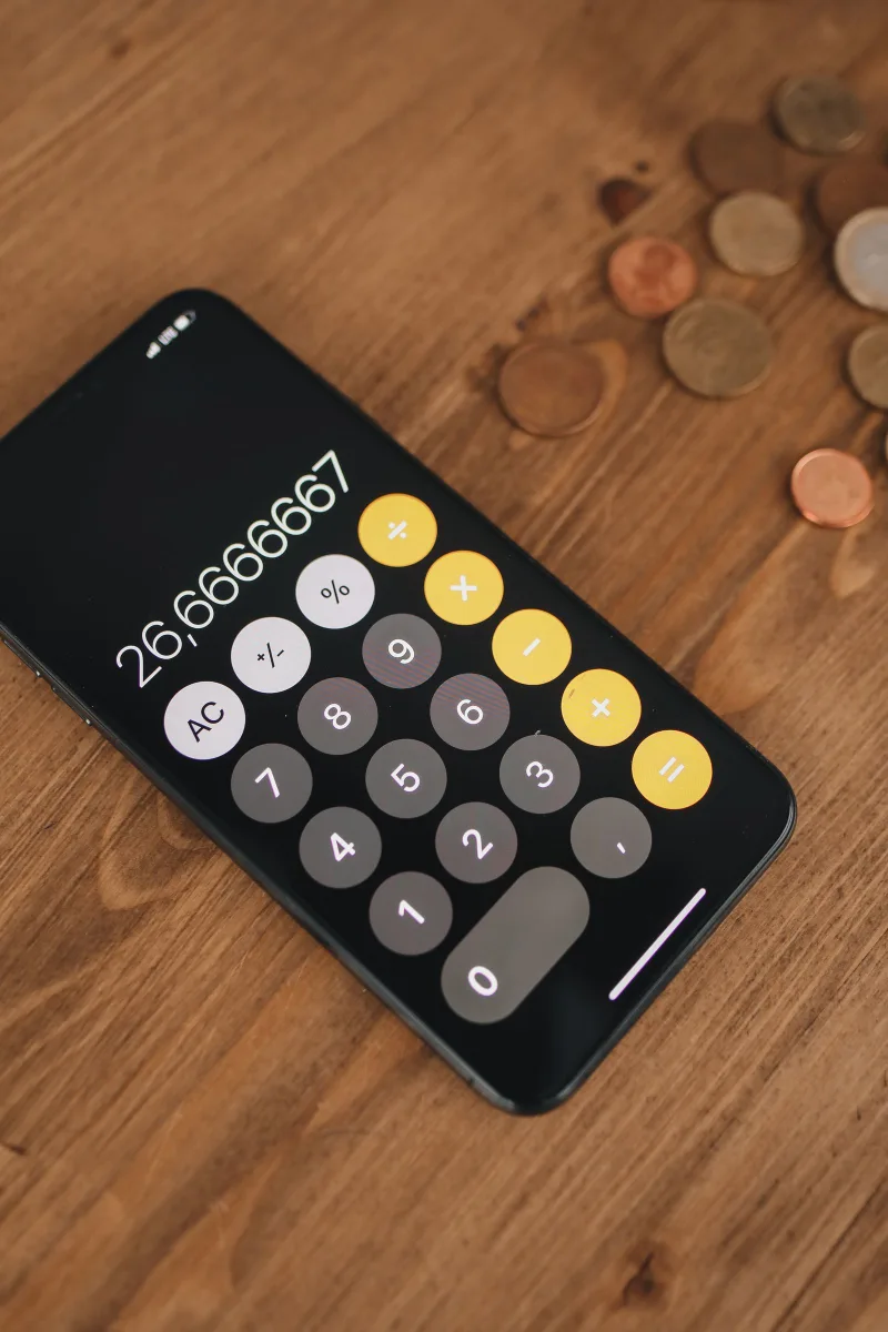 A smartphone displaying a calculator app with coins, representing AI budgeting apps