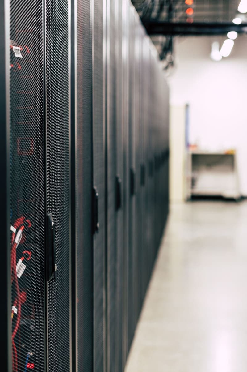 Interior of a hyperscale AI data center with rows of illuminated server racks